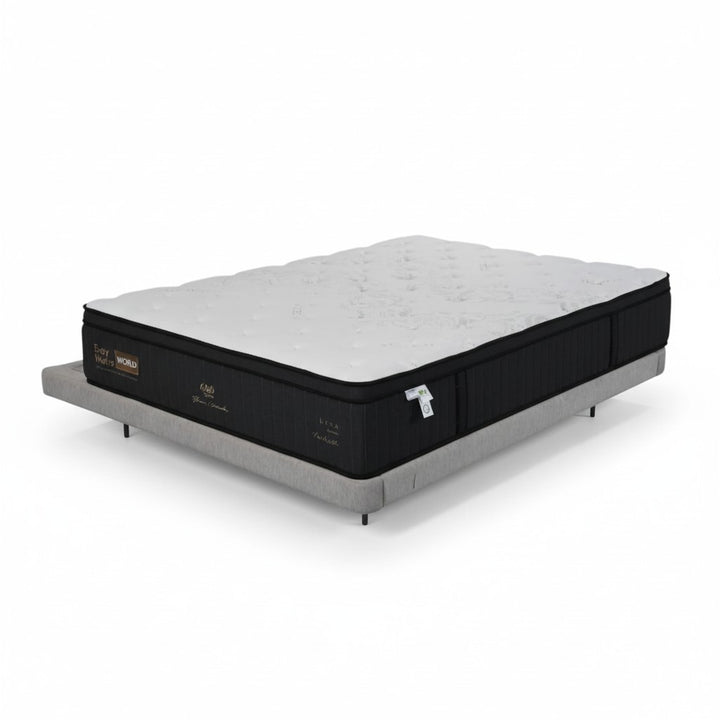 Modern queen mattress with black sides and white top on a minimalist upholstered bed base