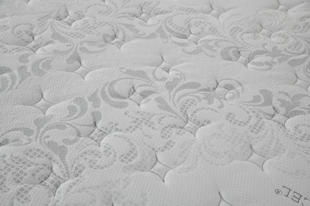 Close-up of a white mattress surface with intricate quilted pattern and soft texture