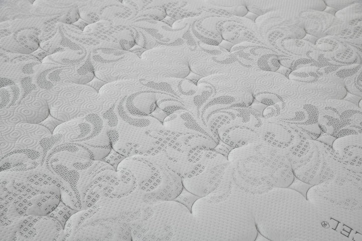 Close-up of a white mattress surface with textured, decorative stitching pattern