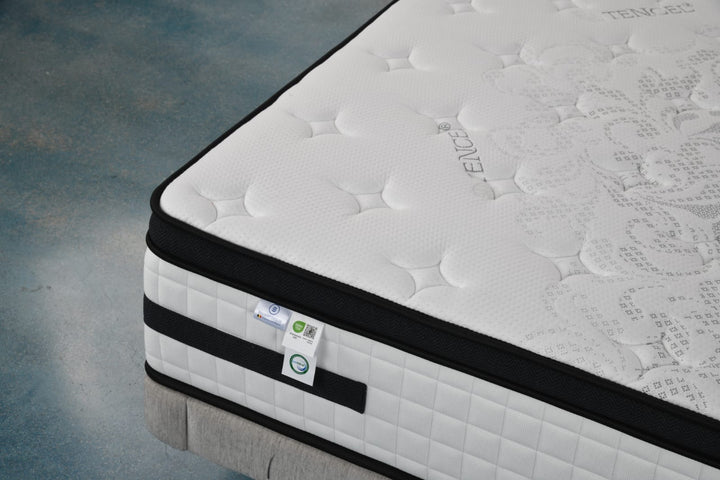 Close-up of a white Tencel fabric mattress with black trim and quilted pattern on bed base