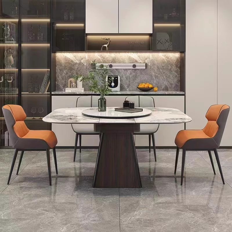 Modern marble dining table with orange cushioned chairs in a stylish kitchen setting