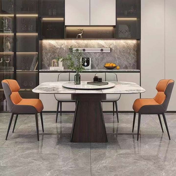 Modern marble dining table with orange cushioned chairs in a stylish kitchen setting