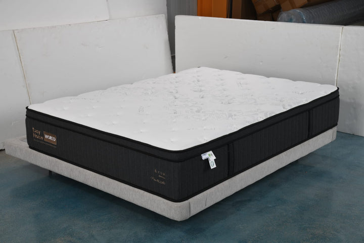 Queen size black and white mattress on a light grey bed base in a modern room