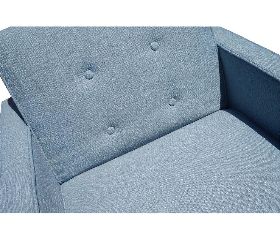 Close-up of blue upholstered armchair with button-tufted backrest and seat