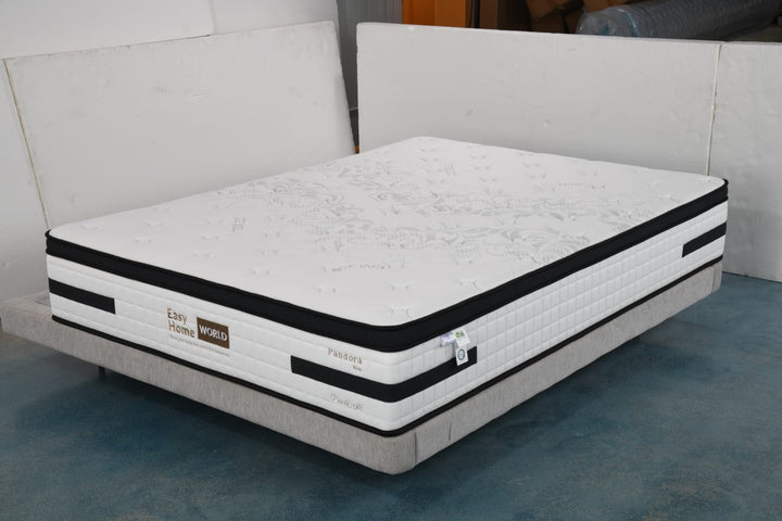 Modern thick white mattress with black trim on fabric bed base, floral top design, in showroom setting