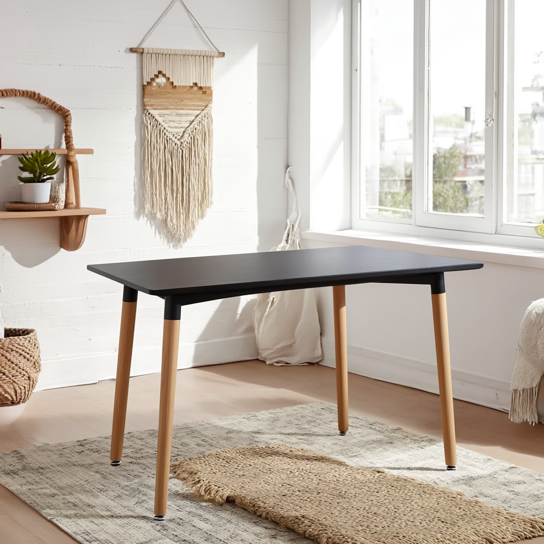 Modern black dining table with light wood legs in bright Sydney home setting