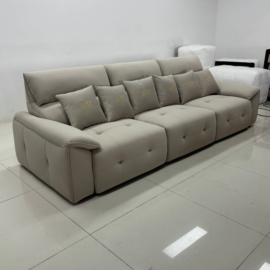 Modern beige sectional sofa with monogram pillows in a minimalist living room