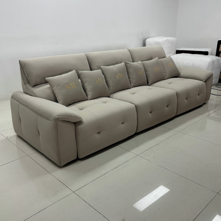 Modern beige sectional sofa with monogram pillows in a minimalist living room