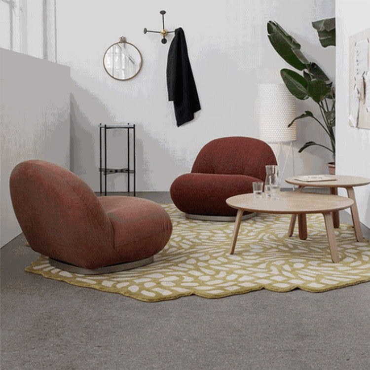 Modern red armchairs with wooden coffee tables on patterned rug in stylish living room