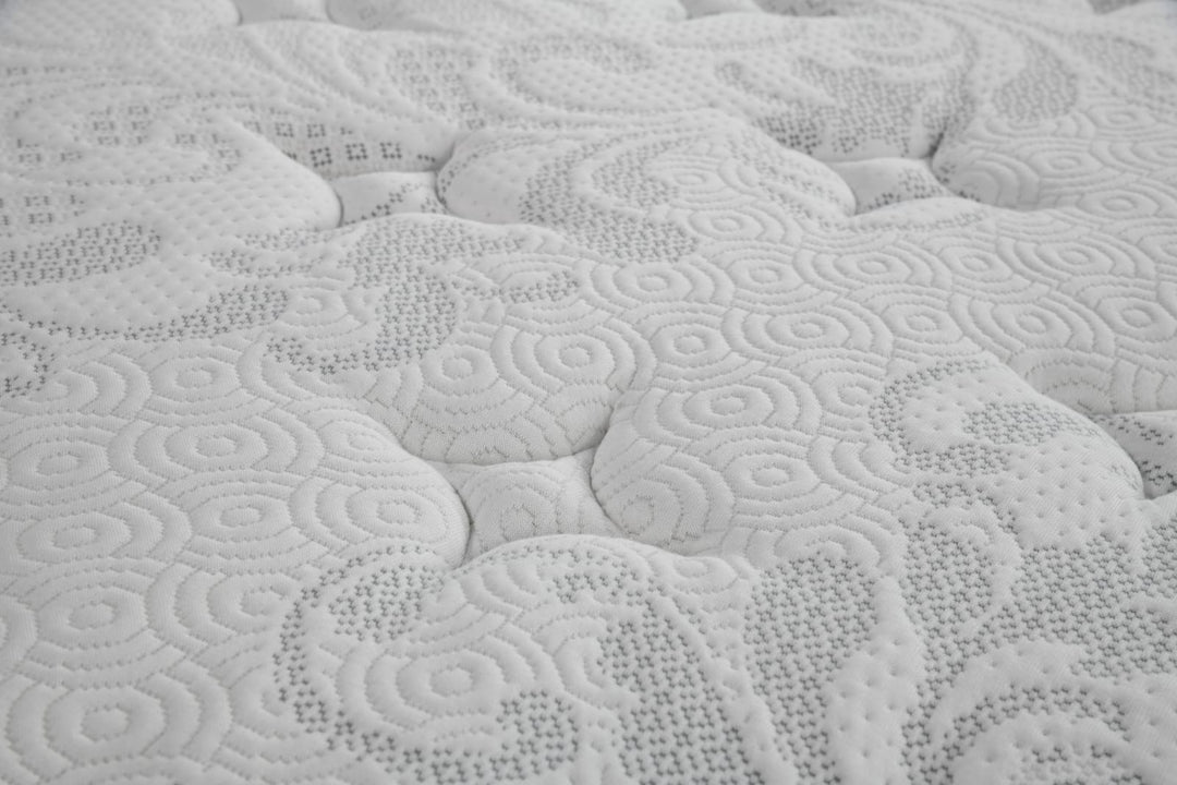 Close-up of white mattress surface with quilted, textured pattern for home bedroom