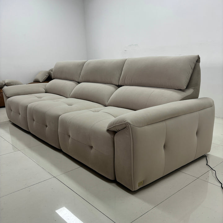 Modern beige sectional sofa with tufted upholstery in a minimalist living room setting