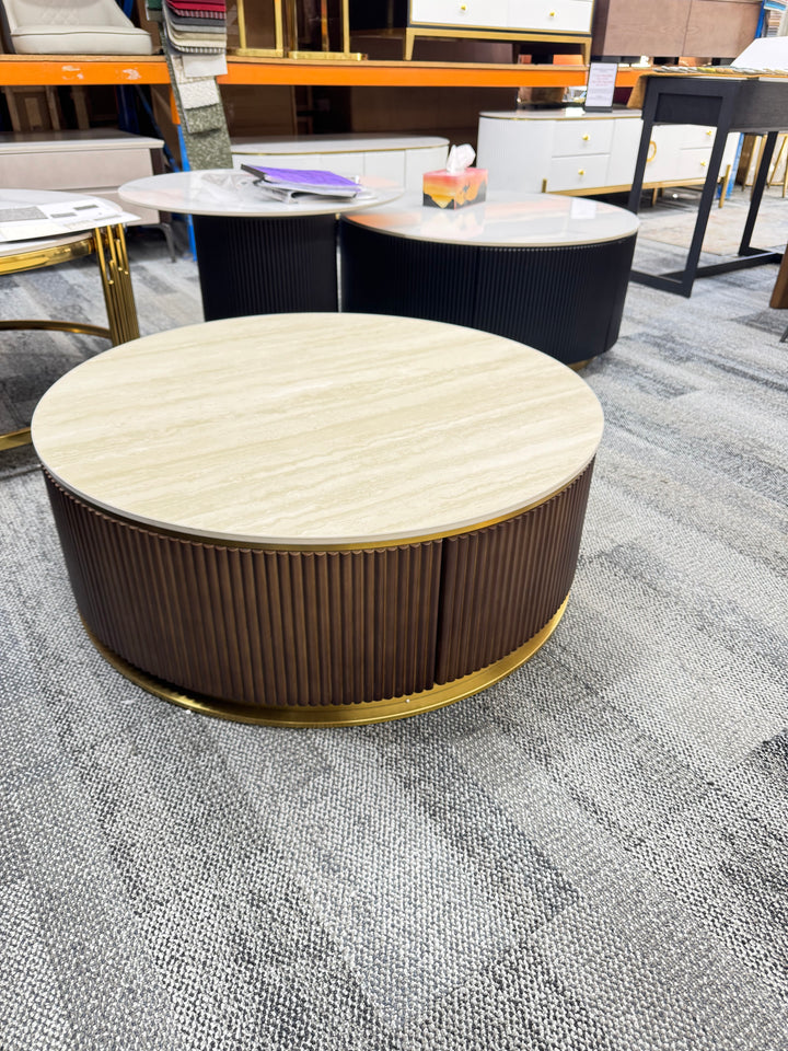 Modern round coffee table with wood panel base and marble top in a furniture showroom