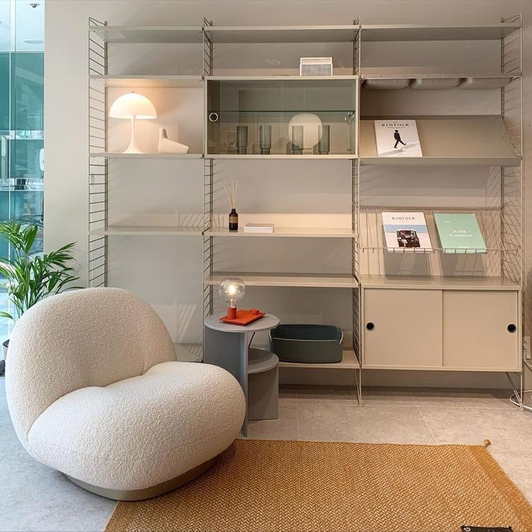 Modern white boucle armchair with modular shelving unit, perfect for Sydney living room furniture