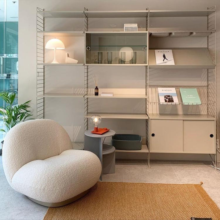 Modern white boucle armchair with modular shelving unit, perfect for Sydney living room furniture