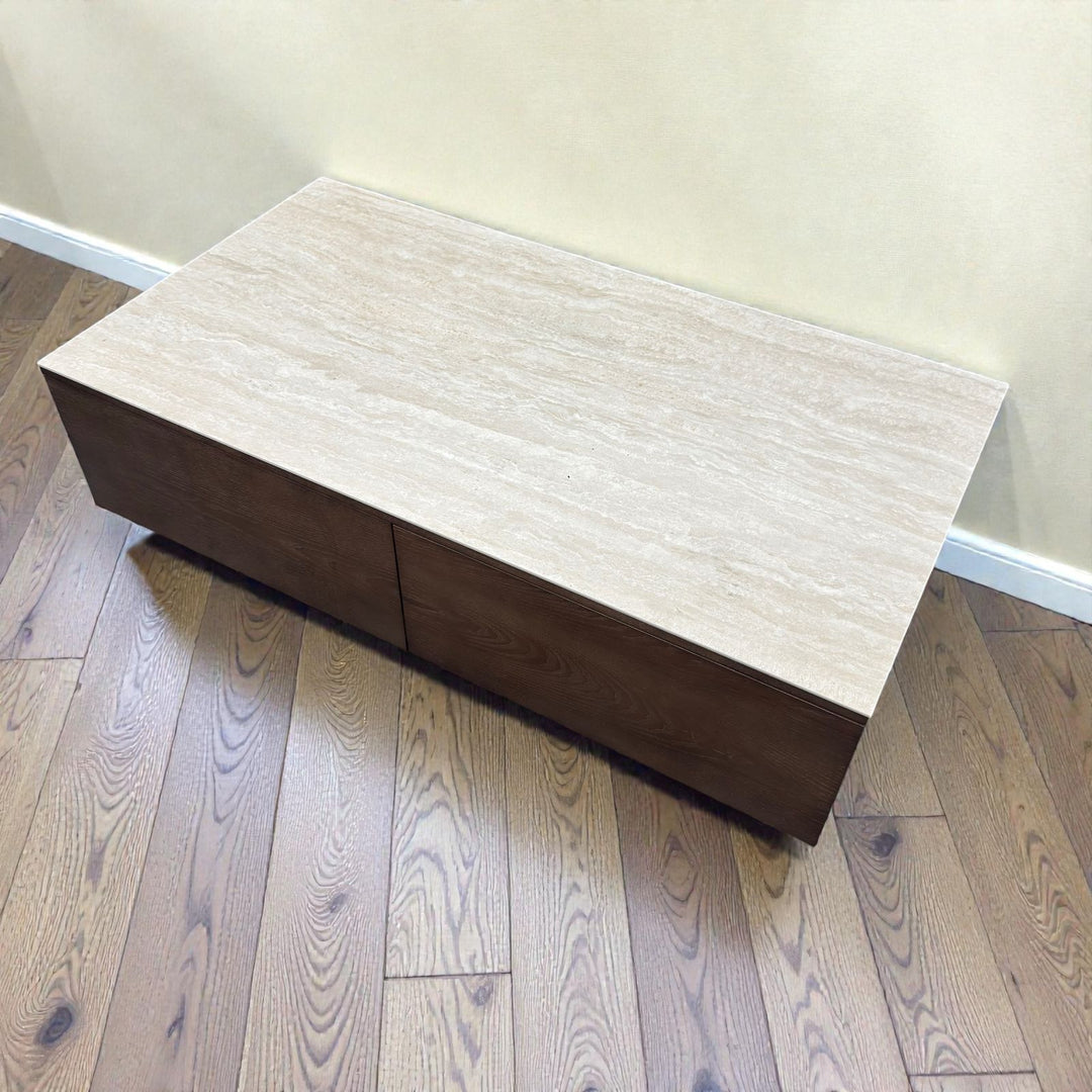 Modern rectangular coffee table with light stone top and dark wooden base on hardwood floor