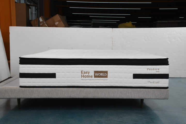 Firm white mattress with black trim on a light bed base, labeled Easy Home World and Pandora.