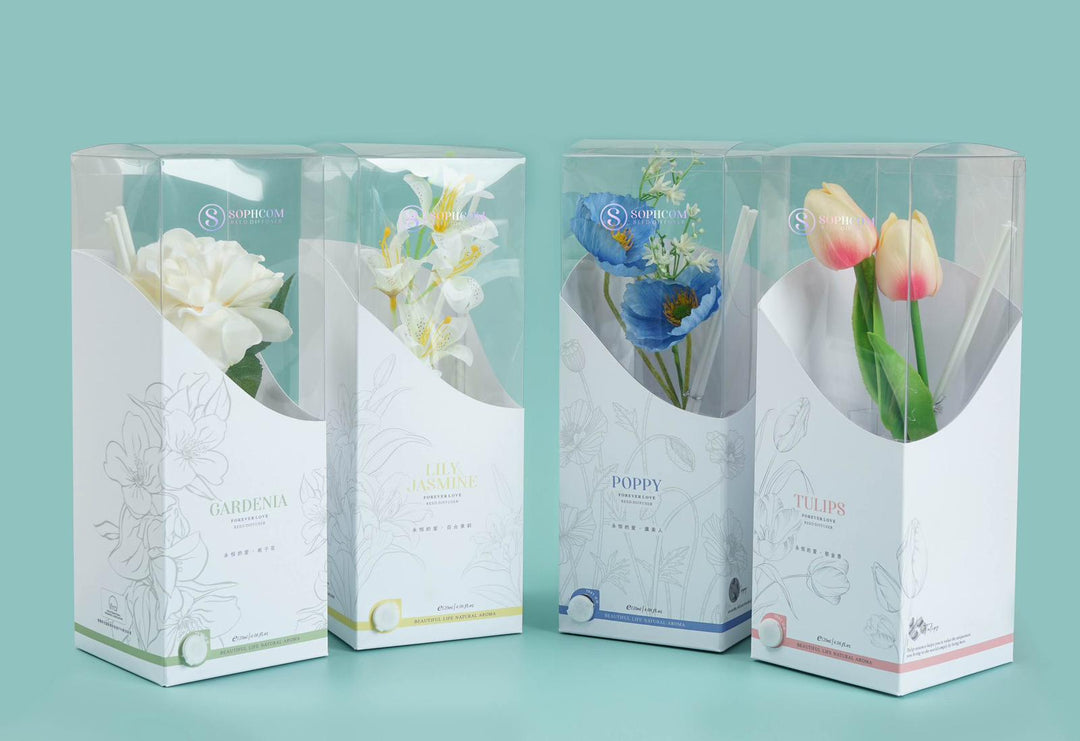 Four boxed reed diffusers with artificial flowers: gardenia, lily jasmine, poppy, and tulips.
