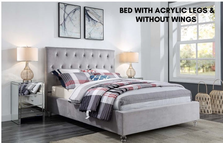 Light grey upholstered bed with acrylic legs, no wings, in a modern bedroom setting
