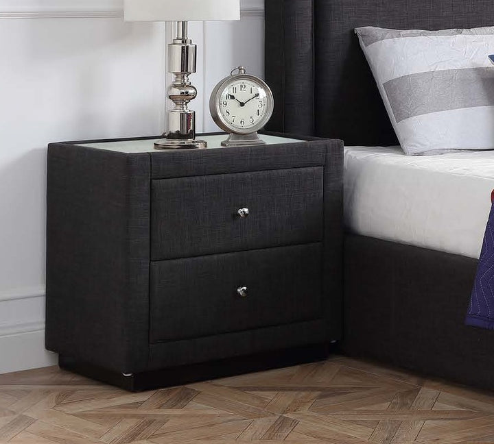 Modern black nightstand with glass top beside bed, featuring lamp and clock, bedroom furniture