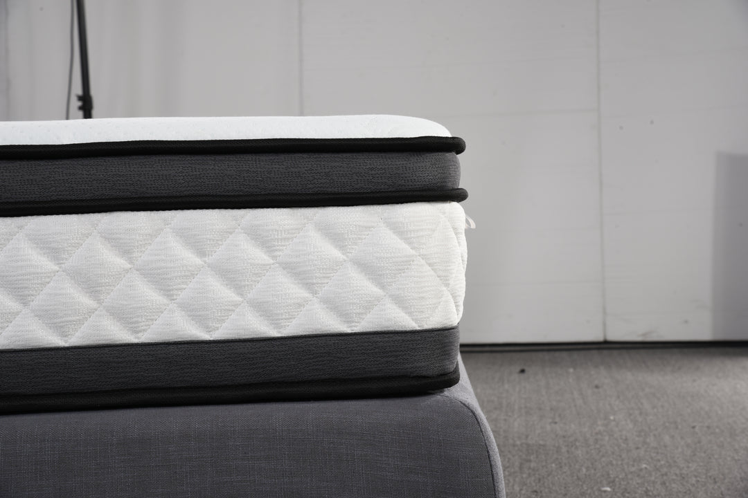 Close-up of a quilted, pillow top mattress on a grey bed base in a modern setting