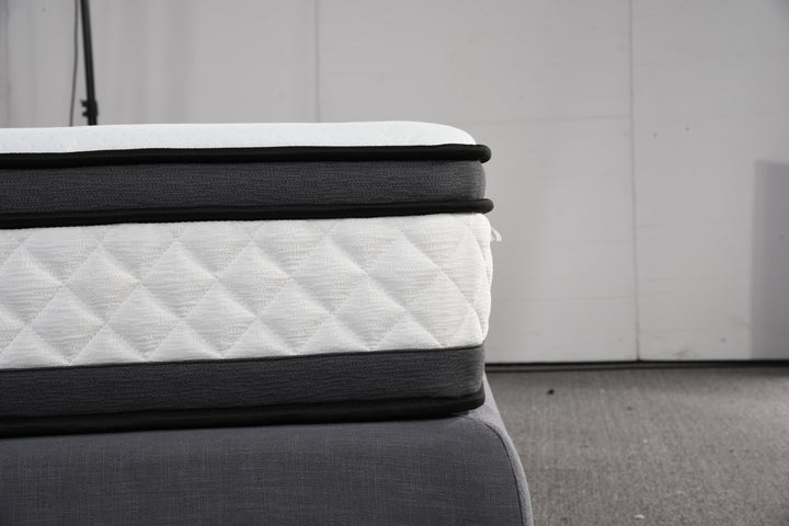 Close-up of a quilted, pillow top mattress on a grey bed base in a modern setting