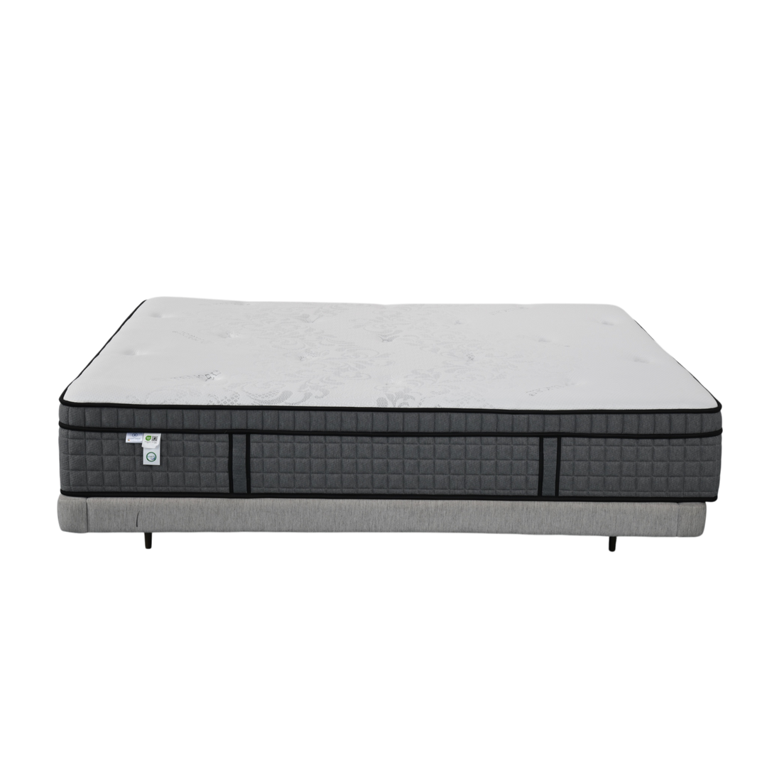 Modern queen mattress with white top and quilted dark gray sides on gray bed base