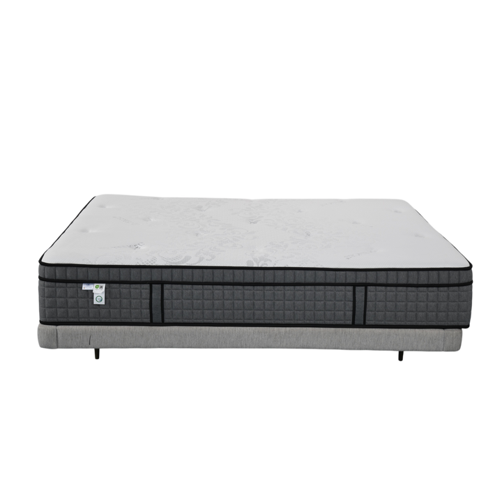 Modern queen mattress with white top and quilted dark gray sides on gray bed base