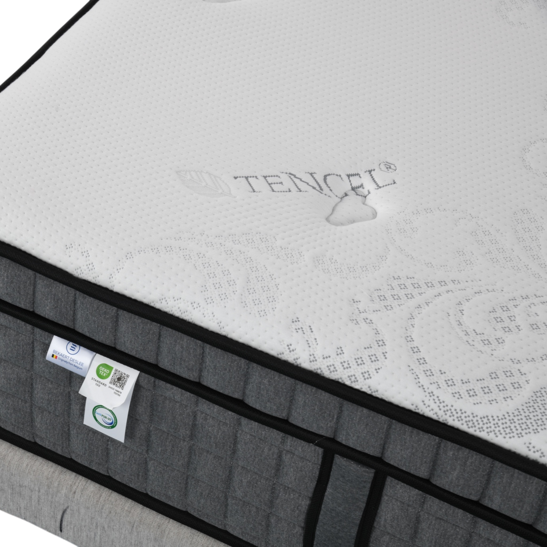 Close-up of a grey and white Tencel fabric mattress with tags and textured surface