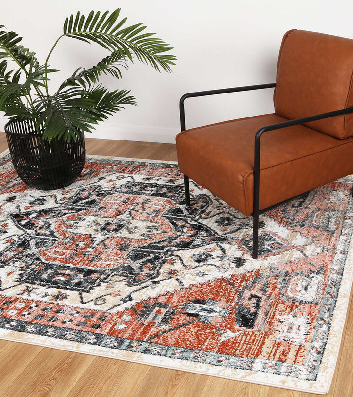 Modern living room with geometric patterned area rug, brown armchair, and potted plant