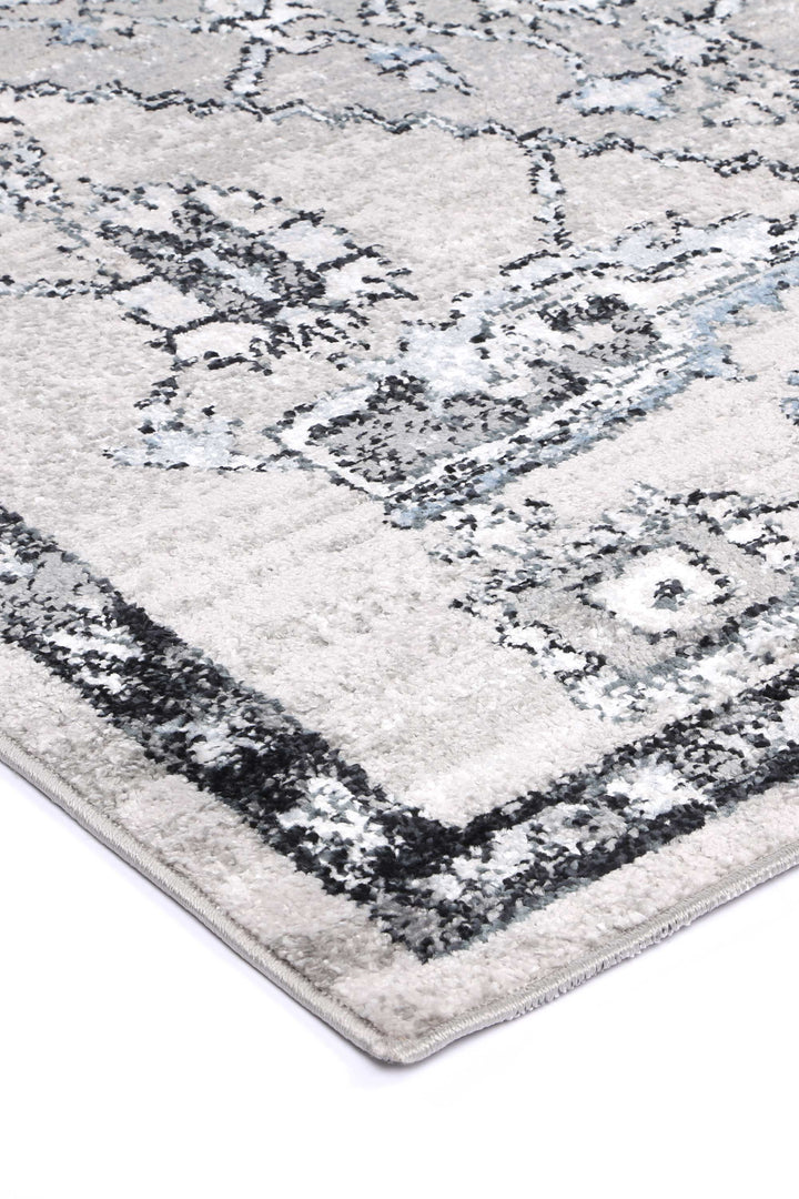 Grey area rug with black and white geometric pattern and modern distressed details