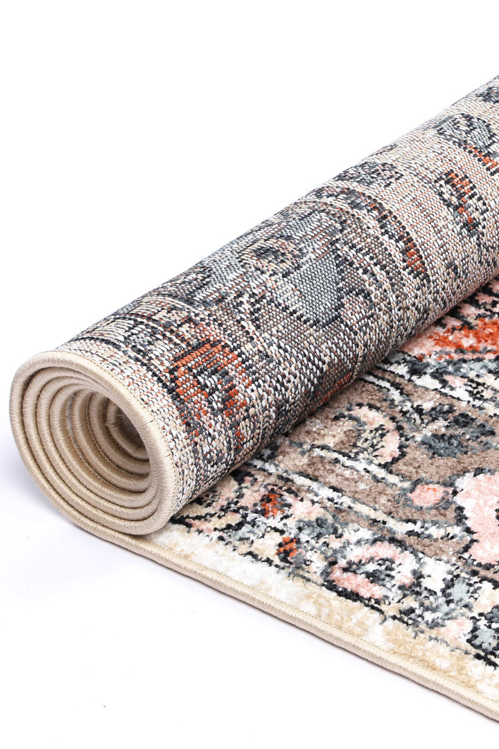 Beige rolled area rug with abstract patterns in brown, orange, and black tones on white background