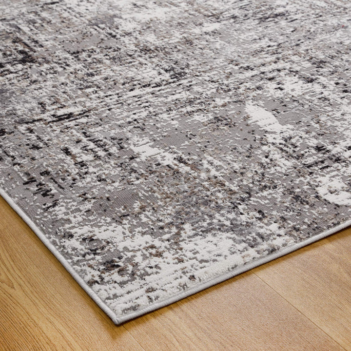 Modern abstract area rug with gray and beige tones on wooden floor