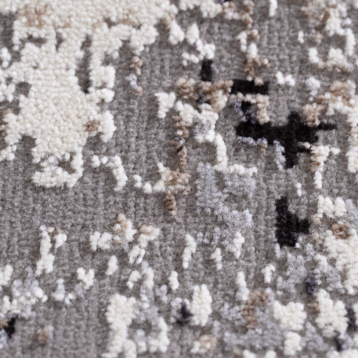 Close-up of modern textured area rug in gray, beige, and black abstract pattern
