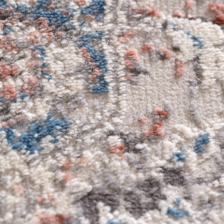 Close-up of soft textured area rug with blue, grey, and blush abstract pattern