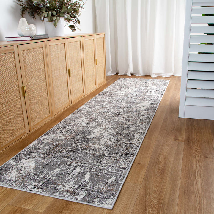 Modern gray hallway runner rug on wood floor beside light oak sideboard and white curtains