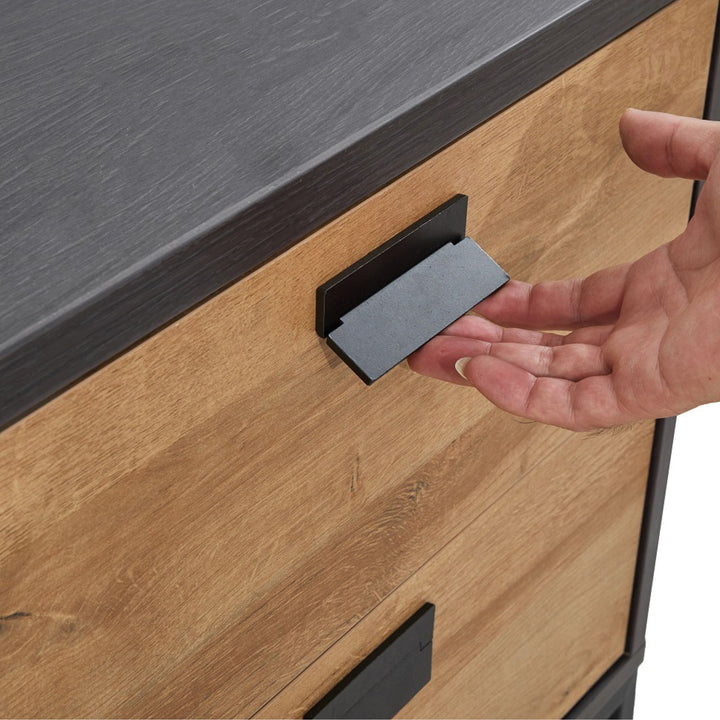 Hand pulling open a modern wood dresser drawer with black metal handle