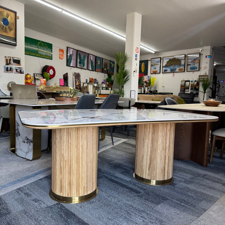 Modern marble-top dining table with wood base in a contemporary furniture showroom