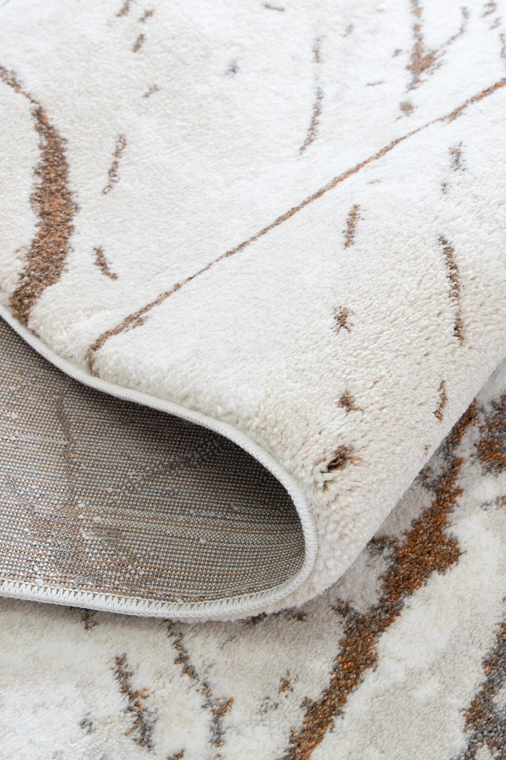 Close-up of a soft, cream and brown patterned area rug showing texture and thickness
