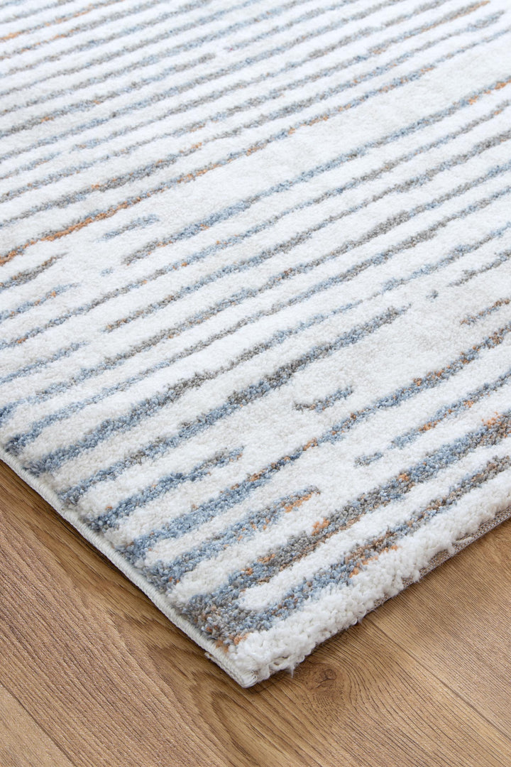 Modern area rug with blue and beige stripes on wooden floor