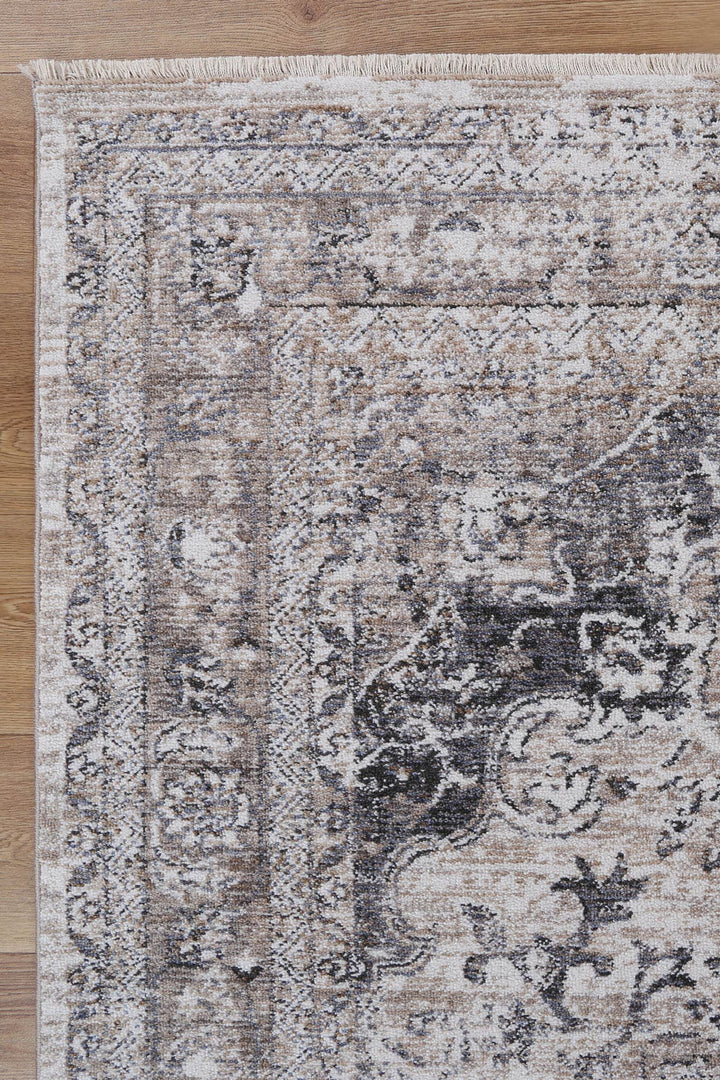 Beige and grey vintage-style area rug with ornate pattern on wooden floor