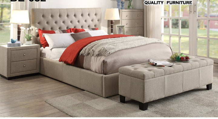 Modern beige upholstered bed with tufted headboard, matching bench, and nightstands in stylish bedroom.
