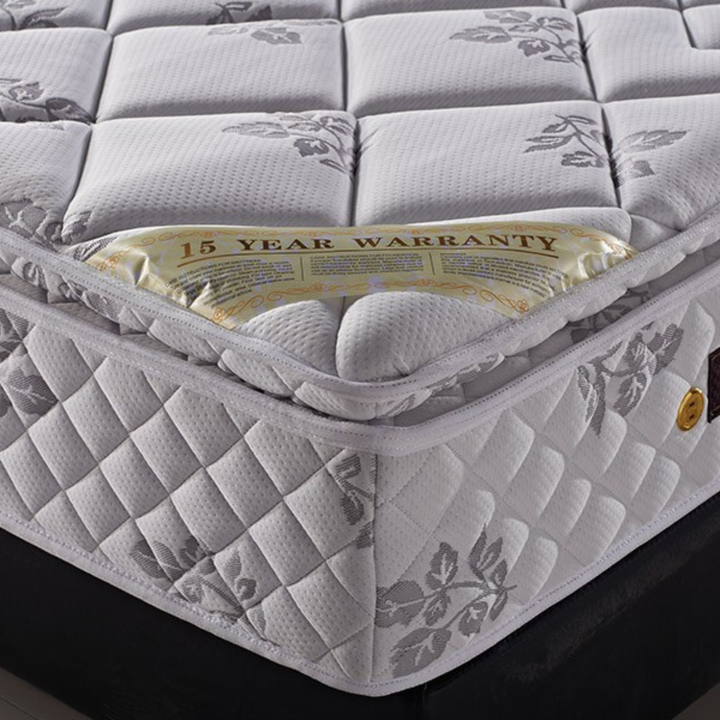 Close-up of a floral-patterned, quilted mattress with a visible 15-year warranty label