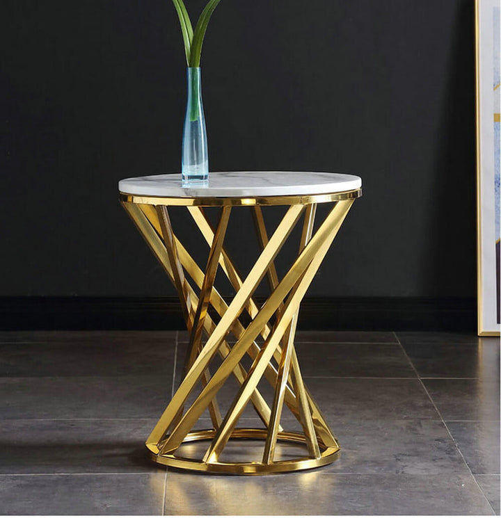 Modern round side table with gold metal base and white marble top, glass vase on top