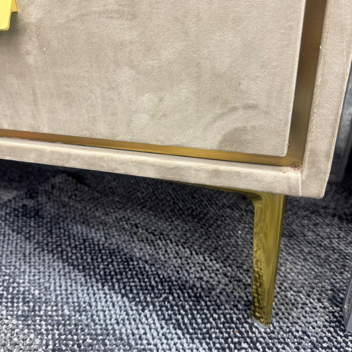 Close-up of modern beige furniture with gold metal leg on textured carpet