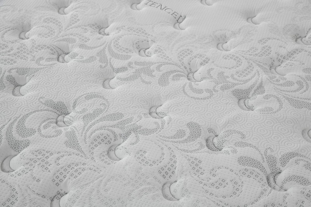 Close-up of a white mattress surface with textured, decorative patterns