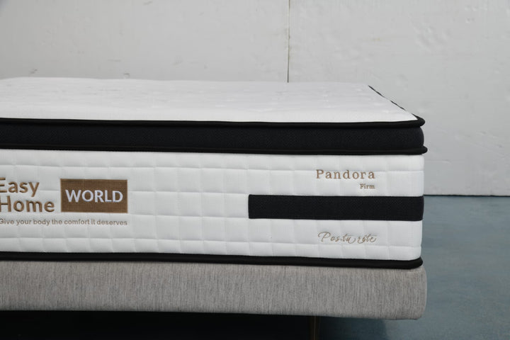 Close-up of a firm Pandora mattress with white quilted cover and black trim on a bed base.