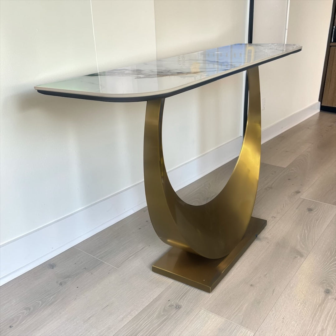 Modern console table with gold metal base and marble top in a contemporary living room