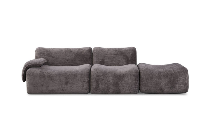 Modern modular dark gray fabric sofa with left armrest and ottoman on white background