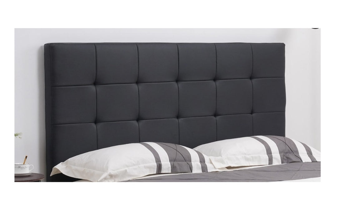 Modern black upholstered bed headboard with square tufted design in a bedroom setting