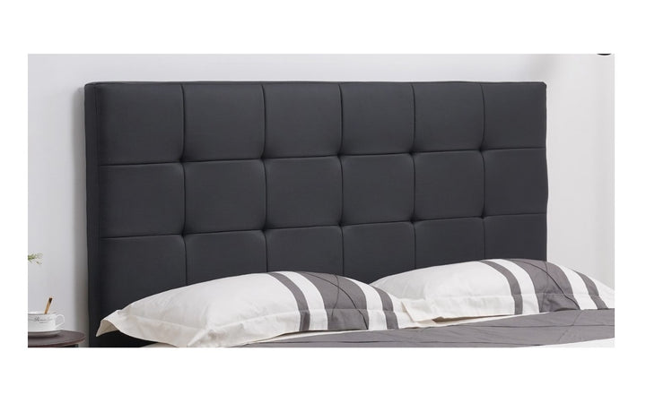 Modern black upholstered bed headboard with square tufted design in a bedroom setting